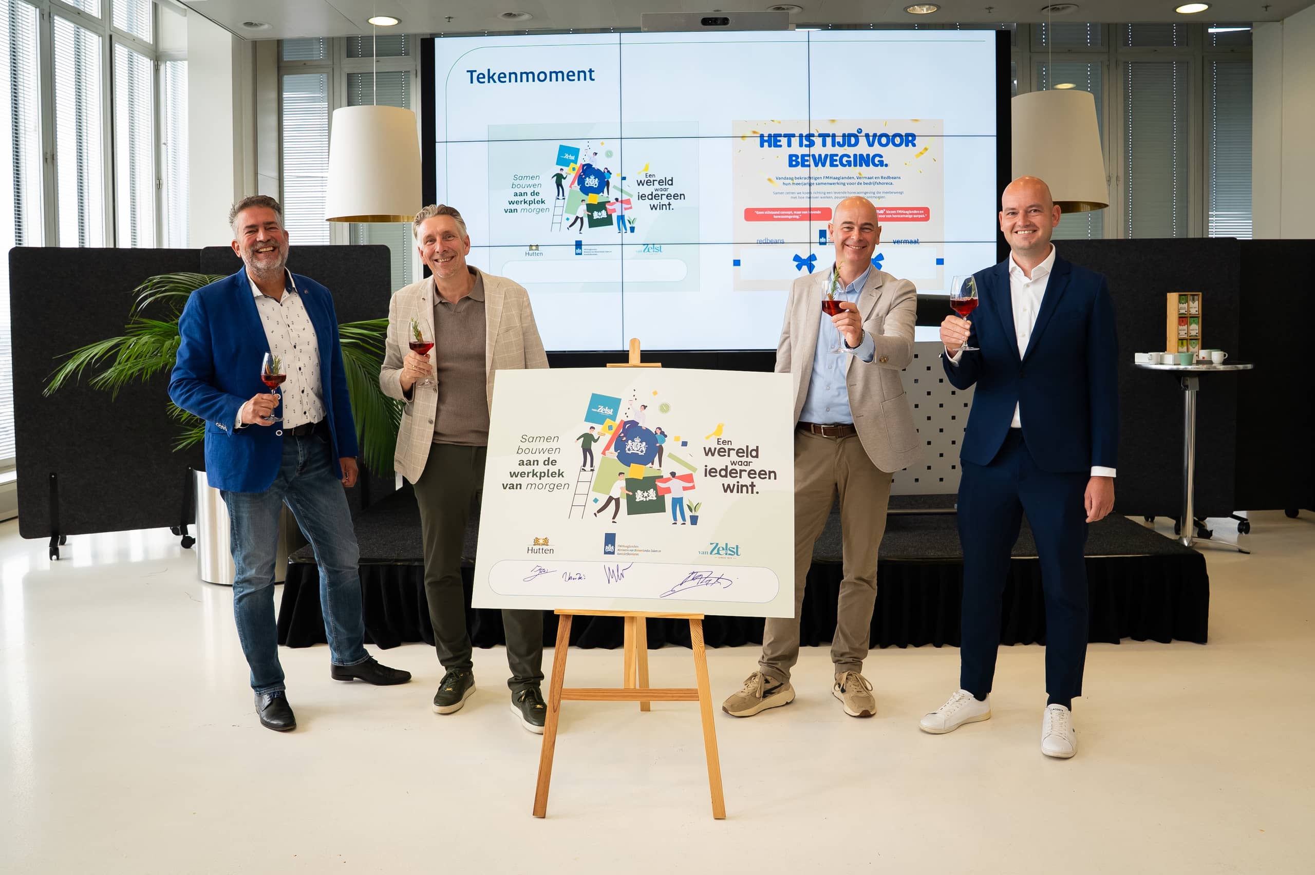 vier mannen heffen het glas