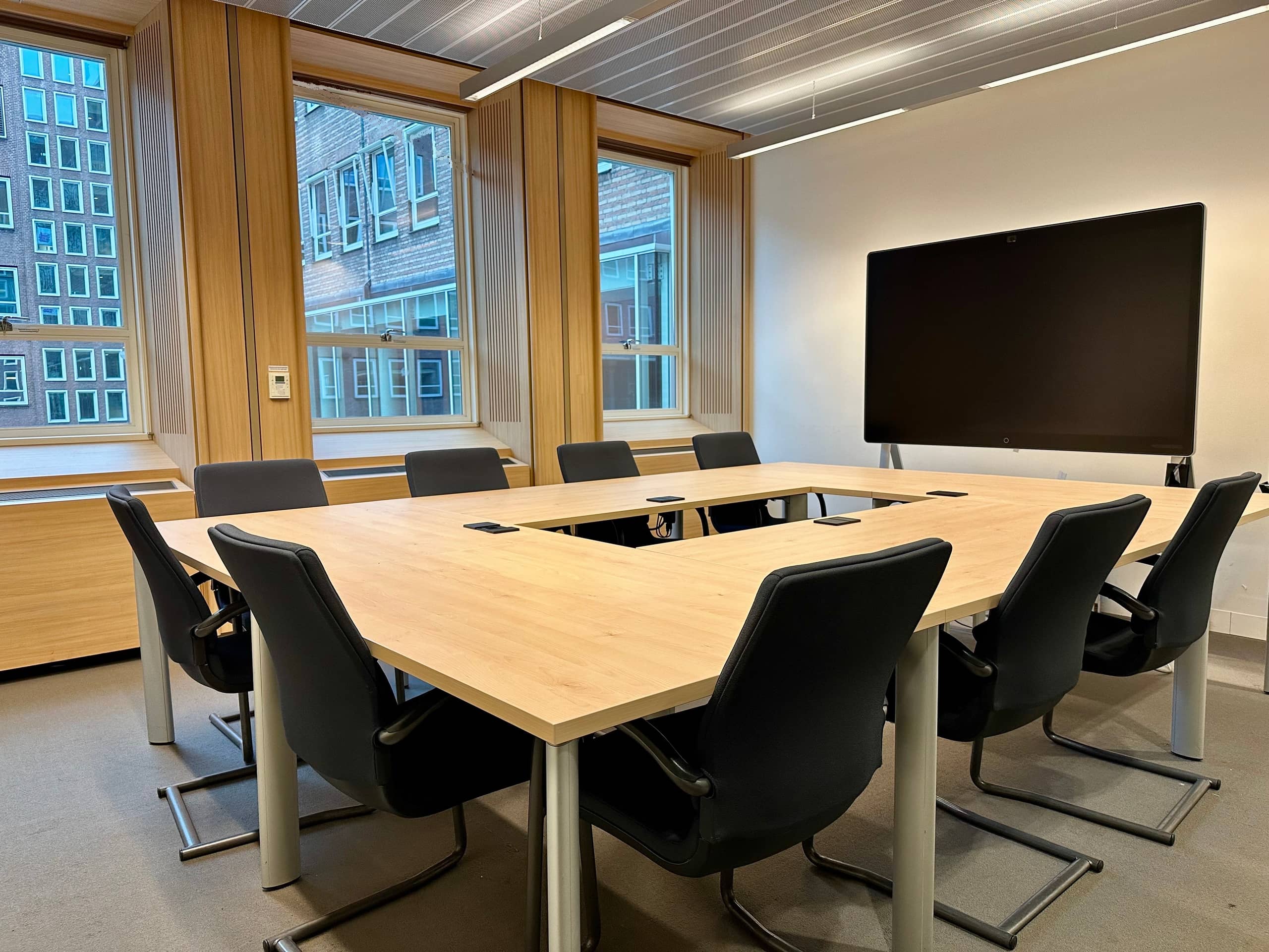 Vergaderzaal met stoelen en grote tafel